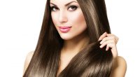 Beautiful brunette woman touching her long shiny straight hair