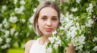 Young romantic woman in spring flowers
